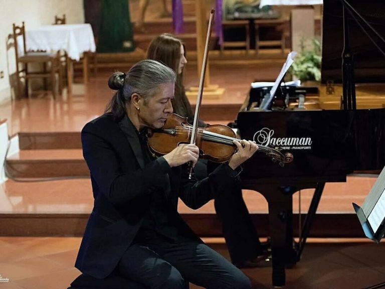 Violinista dell'Experience Trio accanto a un pianoforte a coda Saccuman